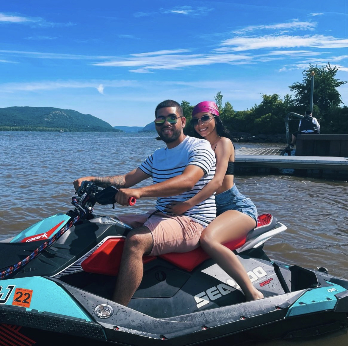 Couple riding a jet ski together on the Hudson River with Catskill Mountains in the background — romantic date idea Hudson Valley NY, couples activities near NYC, summer things to do Hudson Valley